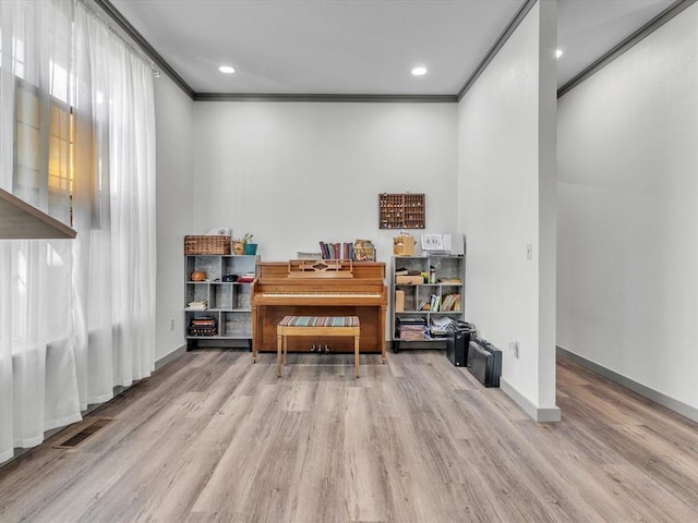 miscellaneous room with light hardwood / wood-style floors and crown molding