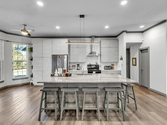 kitchen with ceiling fan, stainless steel fridge, black range with electric cooktop, and a large island with sink