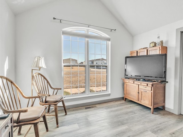 living area featuring light hardwood / wood-style flooring and lofted ceiling