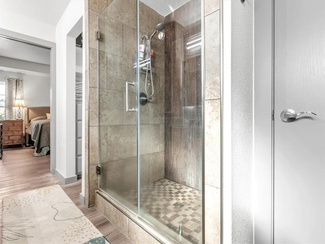 bathroom with wood-type flooring and an enclosed shower