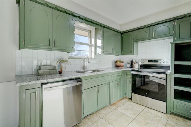 kitchen featuring appliances with stainless steel finishes, tasteful backsplash, sink, green cabinets, and light tile patterned flooring