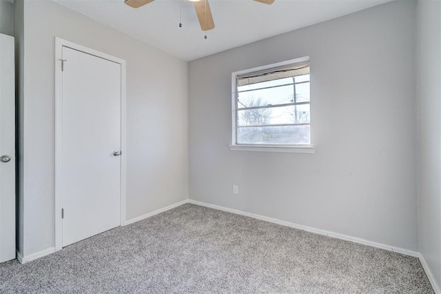 carpeted spare room with ceiling fan