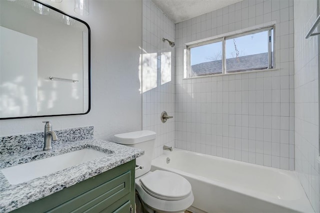 full bathroom featuring toilet, vanity, and tiled shower / bath combo