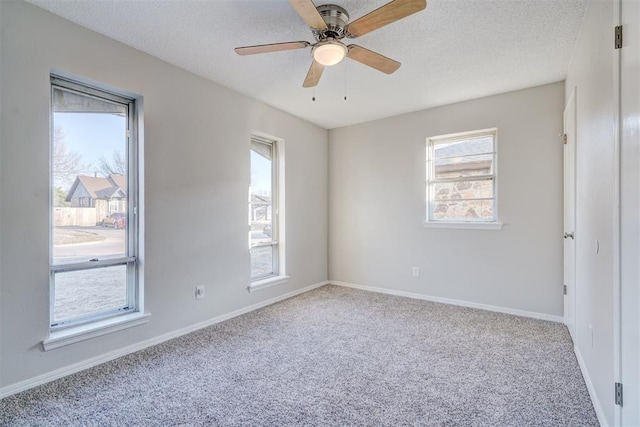 empty room with light carpet, ceiling fan, and a textured ceiling