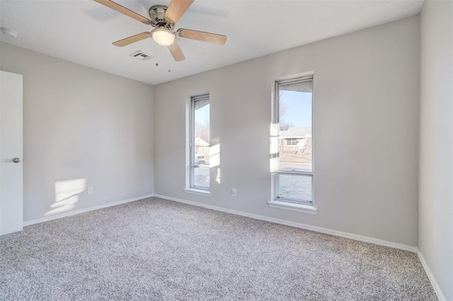 carpeted spare room with plenty of natural light and ceiling fan