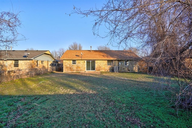 rear view of house with a lawn and cooling unit