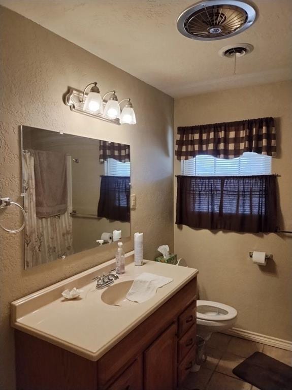 bathroom with tile patterned flooring, vanity, and toilet