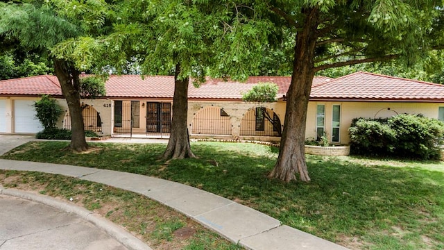 single story home with a front yard and a garage