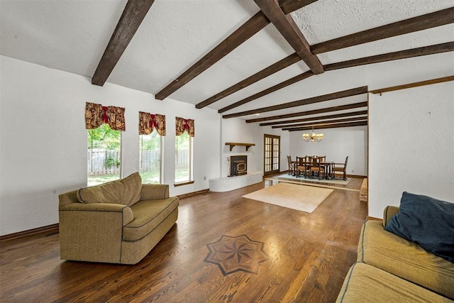 living room featuring a chandelier, a textured ceiling, lofted ceiling with beams, and dark hardwood / wood-style floors