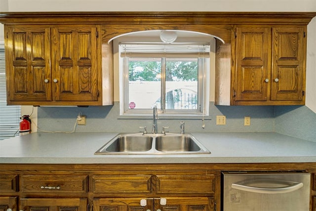 kitchen featuring backsplash, stainless steel dishwasher, and sink