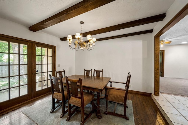 dining space with french doors, ceiling fan with notable chandelier, a textured ceiling, wood-type flooring, and beamed ceiling