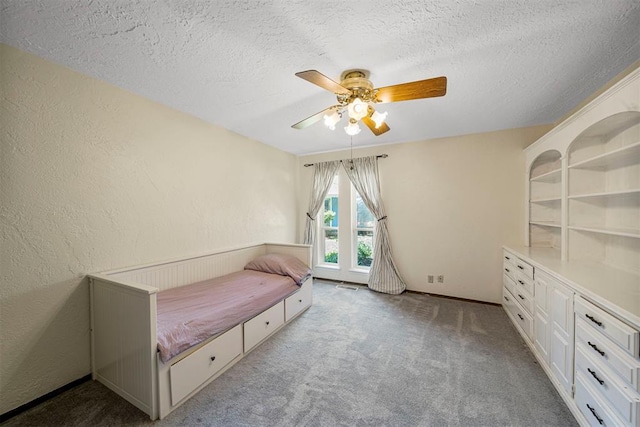 unfurnished bedroom with a textured ceiling, ceiling fan, and light carpet