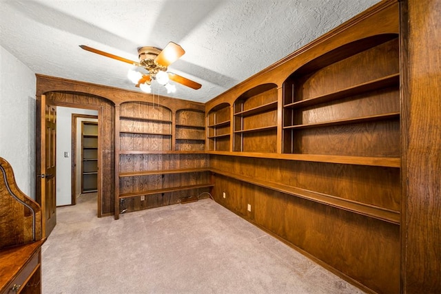 unfurnished office with light colored carpet, ceiling fan, and wooden walls