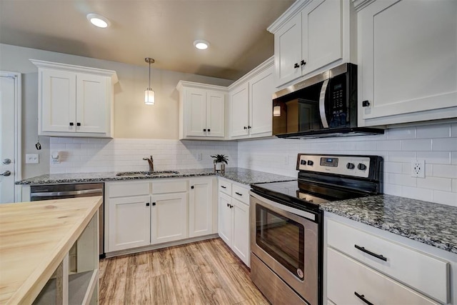 kitchen with appliances with stainless steel finishes, white cabinetry, and sink