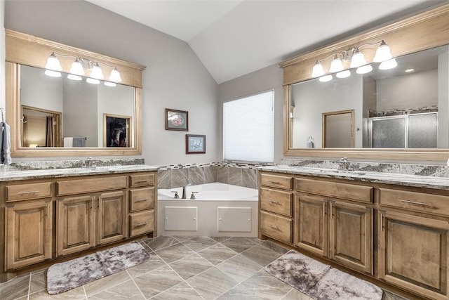 bathroom with vanity, vaulted ceiling, and independent shower and bath