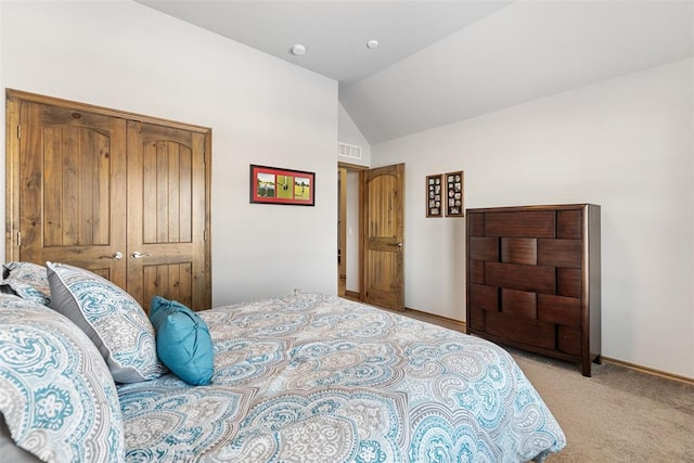 bedroom featuring light colored carpet, lofted ceiling, and a closet