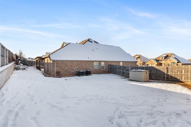 snow covered house featuring cooling unit