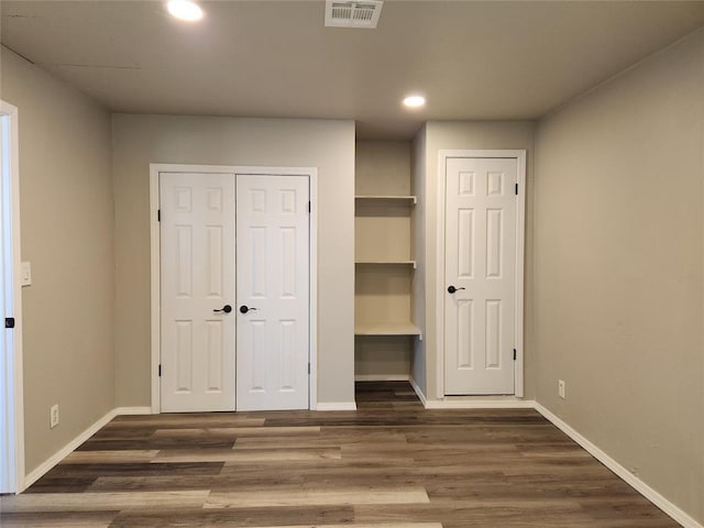 unfurnished bedroom with dark hardwood / wood-style flooring