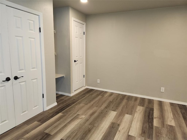 unfurnished bedroom with dark hardwood / wood-style flooring