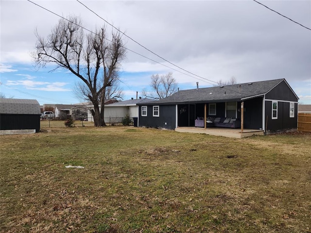 rear view of house with a lawn, a storage shed, and a patio area