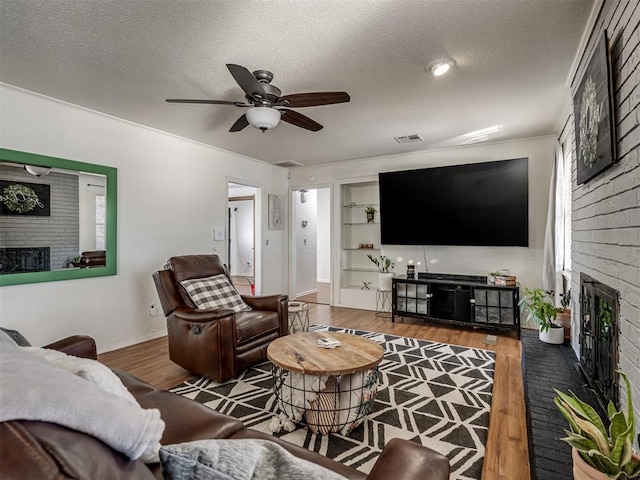 living room with hardwood / wood-style floors, a textured ceiling, and a fireplace