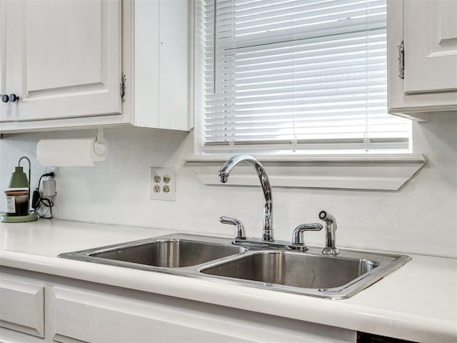 kitchen featuring sink and white cabinets