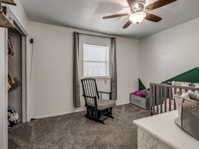 bedroom with ceiling fan, dark carpet, and a textured ceiling