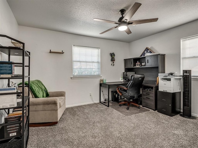 office space with dark colored carpet, ceiling fan, a textured ceiling, and a wealth of natural light