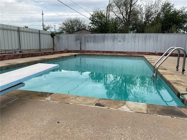 view of swimming pool featuring a diving board