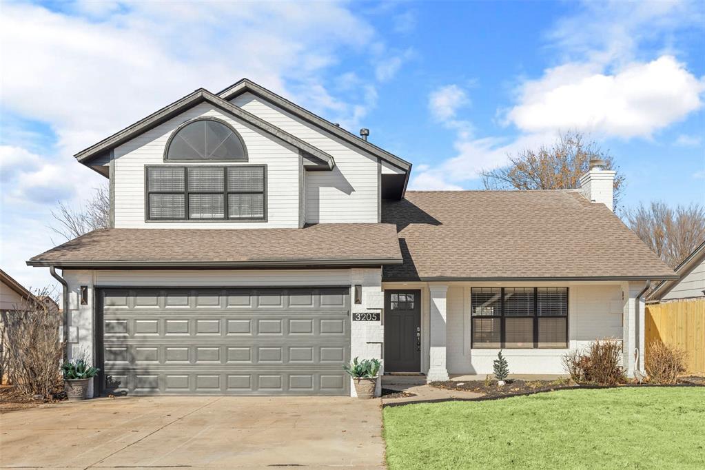 view of front property featuring a garage and a front yard