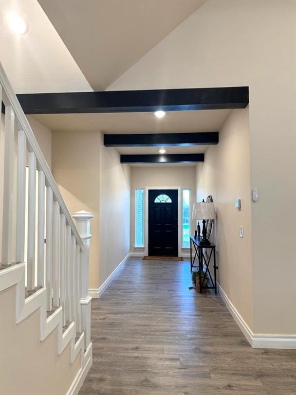 foyer featuring baseboards, stairway, and beam ceiling