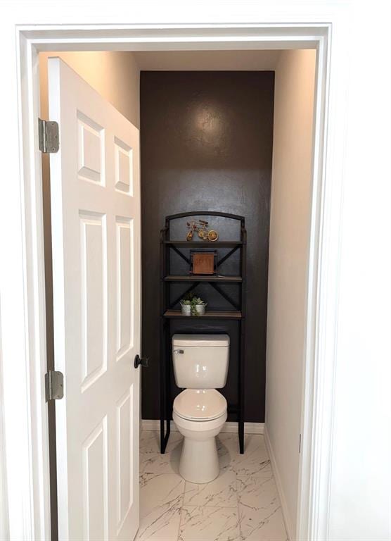 bathroom featuring marble finish floor, toilet, and baseboards