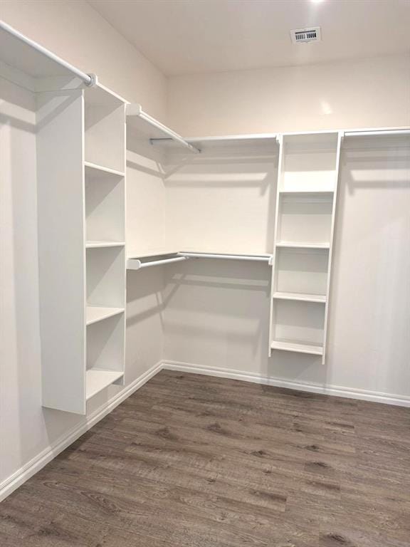 walk in closet featuring visible vents and dark wood-style flooring