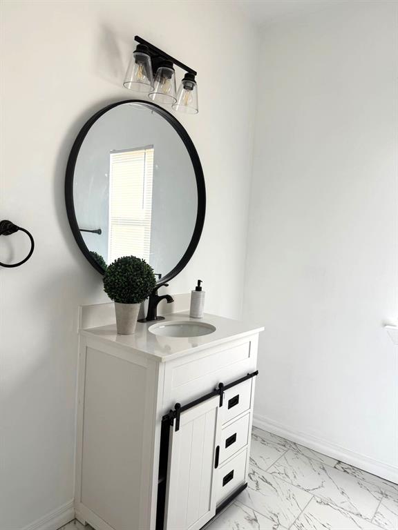 bathroom featuring marble finish floor, baseboards, and vanity