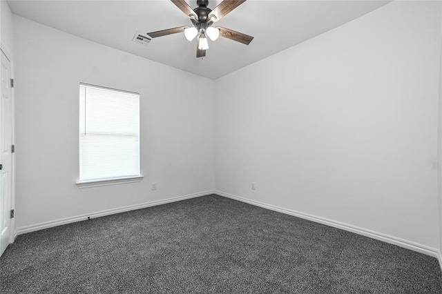 spare room featuring baseboards, dark colored carpet, visible vents, and a ceiling fan