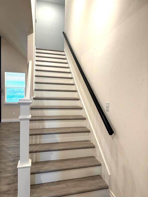 stairs featuring wood finished floors