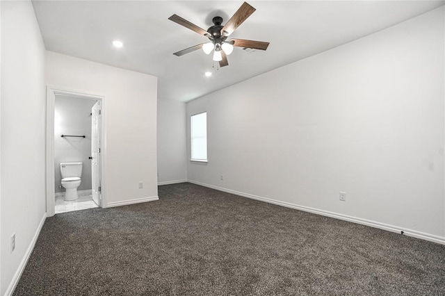 unfurnished bedroom featuring recessed lighting, baseboards, dark colored carpet, and ensuite bathroom