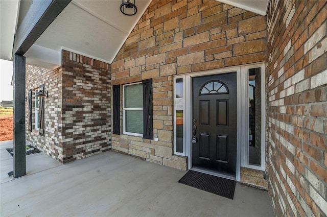 doorway to property with brick siding