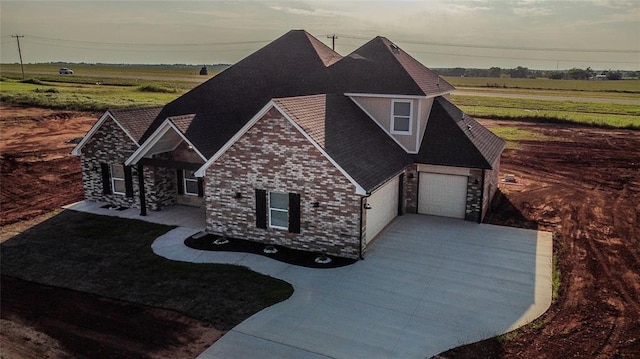 view of front of property with driveway and brick siding