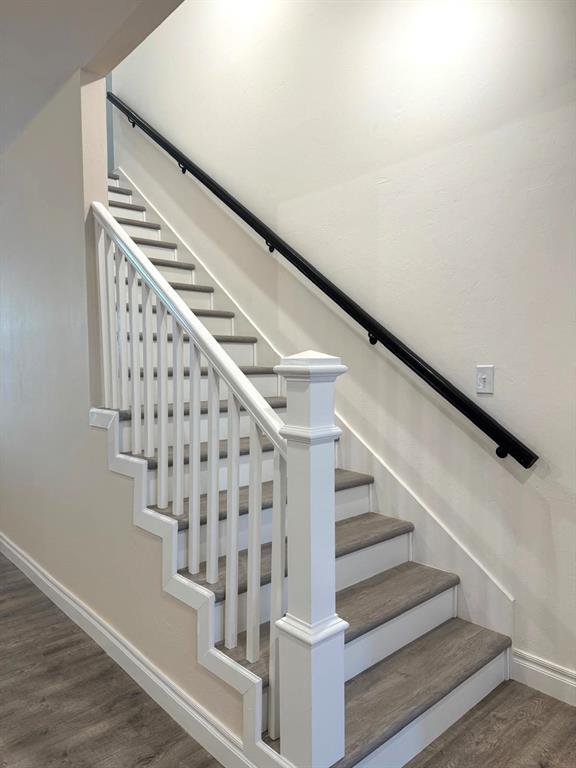 stairway featuring baseboards and wood finished floors