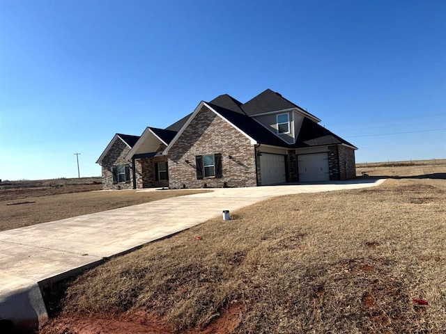 craftsman-style house with a garage, a front lawn, concrete driveway, and brick siding