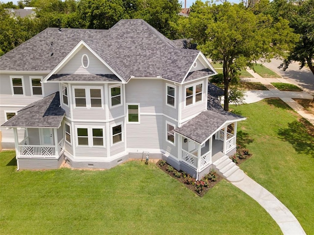 rear view of property featuring a porch and a yard