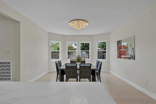 dining area featuring light hardwood / wood-style flooring and an inviting chandelier