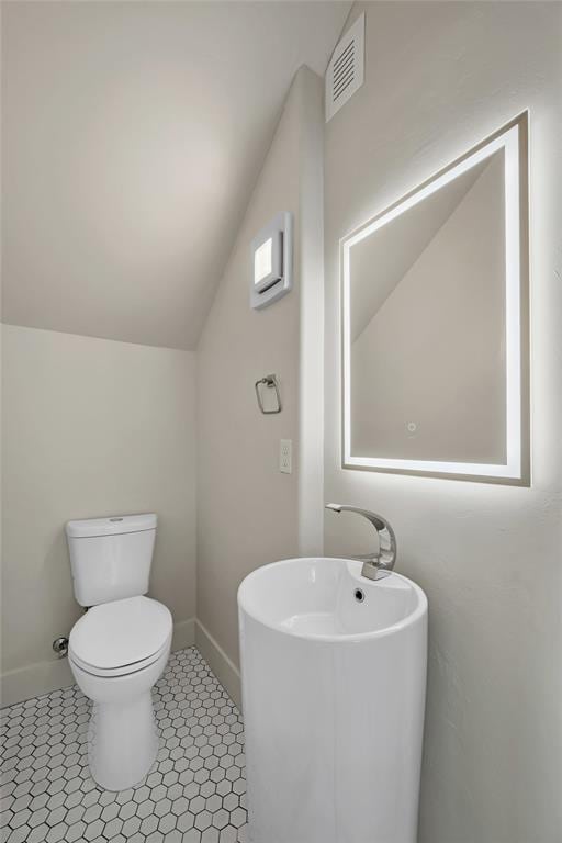 bathroom with toilet and vaulted ceiling