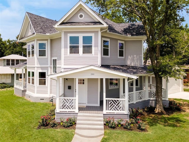 view of front of house with a porch, a garage, and a front lawn