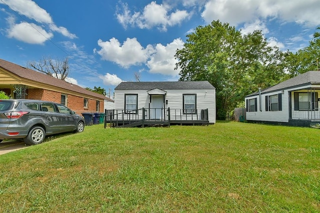 view of front of property with a wooden deck and a front lawn