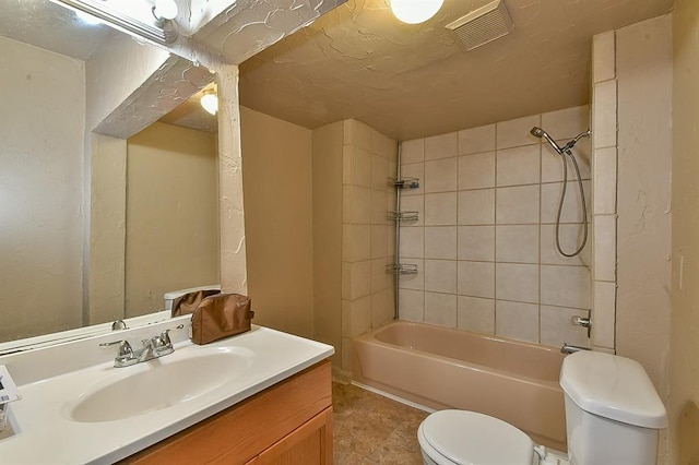 full bathroom with tiled shower / bath combo, vanity, and toilet