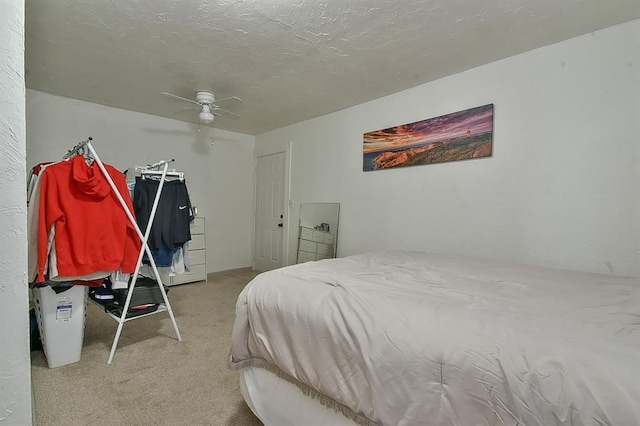 carpeted bedroom with ceiling fan and a textured ceiling