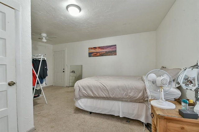 carpeted bedroom with ceiling fan and a closet