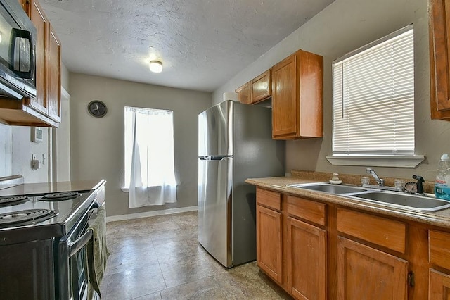 kitchen featuring sink, a textured ceiling, and black appliances